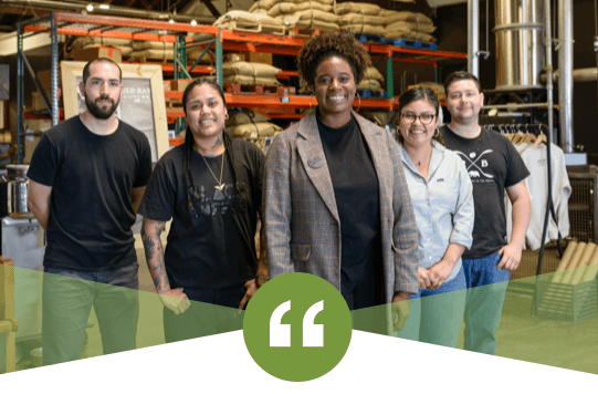 Kenitra Dominguez standing in a warehouse with her co-workers